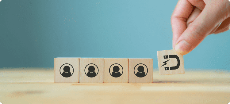 Manos de una persona con una ficha de imán atrayendo otras fichas de usuarios en referencia a la atracción del Inbound Marketing