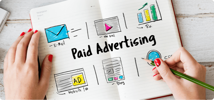 Cuaderno con íconos de diferentes canales para potenciar la publicidad paga en redes sociales